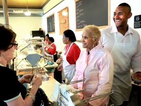 FILE - A customer picks up some to go food from Sweetie Pie's owner Robbie Montgomery, center, and Montgomery's son James "Tim" Norman, right, at Sweetie Pie's in St. Louis, on April 19, 2011. Norman, former star of "Welcome to Sweetie Pie's" reality TV show, testified Tuesday, Sept. 13, 2022, that he was not involved in the murder of his nephew. Norman is accused of hiring two people to kill 21-year-old Andre Montgomery in March 2016 and then trying to cash a $450,000 life insurance policy he took out on his nephew in the months before he was killed.