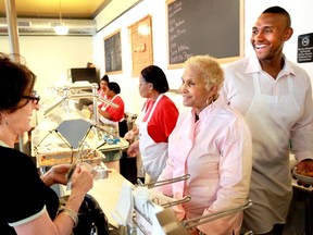 A customer picks up some to go food from Sweetie Pie's owner Robbie Montgomery, center, and Montgomery's son James Timothy Norman, right, at Sweetie Pie's in St. Louis on April 19, 2011. A murder-for-hire trial involving former stars of the reality TV show "Welcome to Sweetie Pie's" got underway in St. Louis, where prosecutors allege that James "Tim" Norman arranged his nephew's killing because he needed money from a life insurance policy that he took out on the victim.