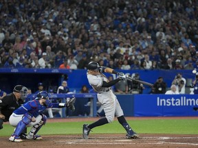 New York Yankees designated hitter Aaron Judge (99) hits his 61st home run of the season, a two-run shot, as Toronto Blue Jays catcher Danny Jansen (9) looks on during seventh inning American League MLB baseball action in Toronto on Wednesday, September 28, 2022.