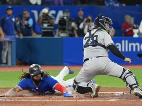 Toronto Blue Jays first baseman Vladimir Guerrero Jr. (27)slides safely into home plate past New York Yankees catcher Jose Trevino (39) during fourth inning American League MLB baseball action in Toronto on Monday, September 26, 2022.