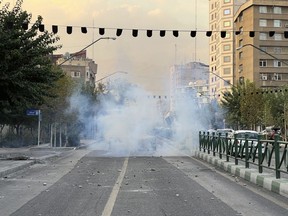 In this Tuesday, Sept. 20, 2022, photo taken by an individual not employed by the Associated Press and obtained by the AP outside Iran, tear gases are thrown by the police during a protest over the death of a young woman who had been detained for violating the country's conservative dress code, in downtown Tehran, Iran. Iran faced international criticism on Tuesday over the death of a woman held by its morality police, which ignited three days of protests, including clashes with security forces in the capital and other unrest that claimed at least three lives. (AP Photo)