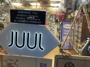 FILE - A Juul electronic cigarette sign hangs in the front window of a bodega convenience store in New York City on June 25, 2022. In a deal announced Tuesday, Sept. 6, 2022, electronic cigarette maker Juul Labs will pay nearly $440 million to settle a two-year investigation by 33 states into the marketing of its high-nicotine vaping products, which have long been blamed for sparking a national surge in teen vaping.