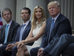 FILE - Donald Trump, right, sits with his children, from left, Eric Trump, Donald Trump Jr., and Ivanka Trump during a groundbreaking ceremony for the Trump International Hotel on July 23, 2014, in Washington. New York's attorney general sued former President Donald Trump and his company on Wednesday, Sept. 21, 2022, alleging business fraud involving some of their most prized assets, including properties in Manhattan, Chicago and Washington, D.C.