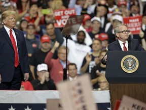 FILE - President Donald Trump listens as Ohio gubernatorial candidate Mike DeWine speaks at a campaign rally on Nov. 5, 2018, in Cleveland. According to a statement Wednesday, Sept. 7, 2022, former President Donald Trump has endorsed DeWine in his reelection bid after deciding against openly backing him in the primary.