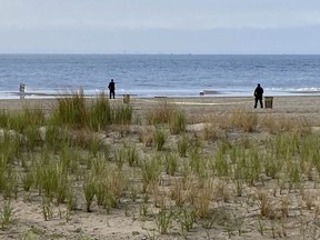 FILE - New York Police investigators examine a stretch of beach at Coney Island where three children were found dead in the surf, Monday, Sept. 12, 2022, in New York. Authorities have confirmed that the children died by drowning.