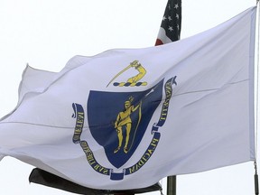 FILE - The Massachusetts state flag flies in front of Boston City Hall, Monday, May 2, 2016. The commission appointed to come up with a new state seal and motto for Massachusetts to replace the current ones that critics decry as insensitive to the state's Indigenous communities disclosed some early ideas, but no firm decisions, at a meeting Tuesday, Sept. 20, 2022.