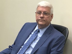 FILE - Ousted Iowa Department of Human Services Director Jerry Foxhoven sits at a news conference in West Des Moines, Iowa, Aug. 1, 2019. A state court judge has dismissed a wrongful discharge lawsuit filed by Foxhoven who accused Gov. Kim Reynolds of improperly diverting federal Medicaid money to pay a member of her staff.