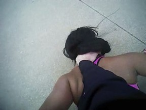 FILE - In this image obtained from Fort Worth Police Officer William Martin's body camera footage, Dec. 21, 2016, Martin holds Jacqueline Craig's daughter down in Fort Worth, Texas. The Texas city has settled a federal civil rights lawsuit filed by Craig, a Black mother, after she and her daughter were wrestled to the ground and arrested by Martin, a white police officer, following a dispute with a neighbor. The city agreed to settle the lawsuit for $150,000, the Fort Worth Star-Telegram reported Friday, Sept. 23, 2022.