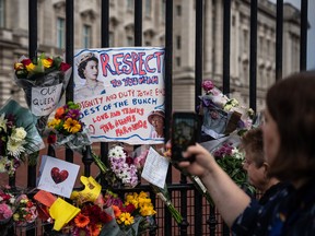 A tribute to Queen Elizabeth II is hung on the fence of Buckingham Palace in London a day after her death, on September 9, 2022.