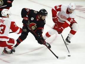 Ottawa Senators' Erik Brannstrom (26), Detroit Red Wings' Adam Erne (73) and Red Wings' Pius Suter (24) chase the puck during third period NHL hockey action in Ottawa on Sunday, April 3, 2022.&ampnbsp;Brannstrom has signed a one-year deal with the Ottawa Senators.