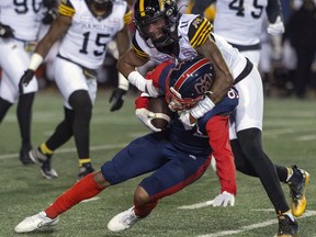 Hamilton Tiger-Cats' Kameron Kelly tackles Montreal Alouettes' Tyson Philpot during first half CFL football action in Montreal on Friday, Sept. 23, 2022.