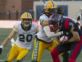 Edmonton Elks' Treston Decoud tackles Montreal Alouettes' Jake Wieneke during first half CFL action in Montreal on Thursday, July 14, 2022.