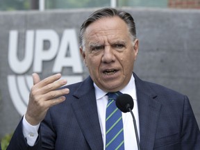 Coalition Avenir Québec Leader François Legault speaks to reporters while campaigning Wednesday, Sept. 7, 2022 outside Montreal.