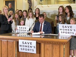FILE - In this March 30, 2022 file photo Oklahoma Gov. Kevin Stitt signs a bill in Oklahoma City that prevents transgender girls and women from competing on female sports teams. Civil rights groups have filed a federal lawsuit on behalf of three transgender Oklahoma schoolchildren against the state's new anti-transgender school bathroom bill. The lawsuit filed in federal district court in Oklahoma City on Tuesday, Sept. 6, 2022 argues that the law requiring students to use only the bathroom of the sex listed on their birth certificate is unconstitutional.