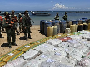 Sacks containing illegal drugs and plastic barrels containing fuel, seized by the armed forces of Venezuela are displayed at a beachside campsite in the village of Tiraya, Venezuela, Monday, Sept. 5, 2022. The armed forces of Venezuela announced what they characterized as the largest marijuana bust of the last 10 years after they intercepted a boat off the country's Caribbean coast over the weekend.