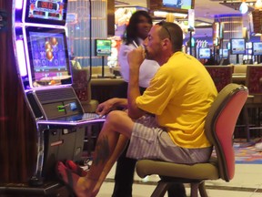 A gambler plays a slot machine in a smoking section of the Hard Rock casino in Atlantic City, N.J on Aug. 8, 2022. A panel discussion on whether smoking should be banned in casinos that was to occur on Sept. 22, 2022 has been canceled after a casino executive pulled out of the forum.