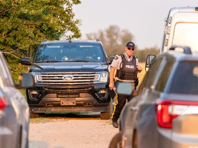 A police officer walks in a crime scene in Weldon, Sask., on Sunday, Sept. 4, 2022.