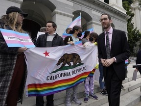 FILE--State Sen. Scott Wiener, D-San Francisco, right, prepares to announce his proposed measure to provide legal refuge to displaced transgender youth and their families during a news conference in Sacramento, Calif., Thursday, March 17, 2022. On Thursday, Sept. 29, 2022, Gov. Gavin Newsom signed Wiener's bill into law.