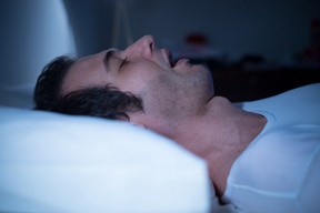 Man is sleeping in his bed at night with sleep apnea
