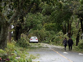 Residents walk past trees and powerlines were downed in Halifax, Nova Scotia, Canada Sept. 24.