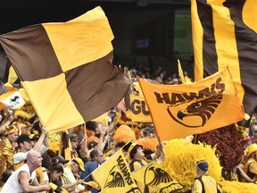 Hawthorn Hawks fans wave flags during the Australian Football League Grand Final between the Hawks and the West Coast Eagles in Melbourne, Oct. 3, 2015. The Australian Football League says, Wednesday, Sept. 21, 2022, it is investigating "very serious allegations" made by Indigenous players that they were racially abused by a coach at the Hawthorn Football Club in Melbourne.
