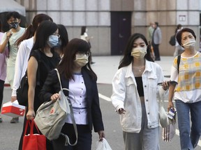 FILE - People wear face masks to protect against the spread of the coronavirus in Taipei, Taiwan on Aug. 31, 2022. Taiwan is considering an end to its quarantine requirement for all arrivals in mid-October, the Central Epidemic Command Center said Thursday, Sept. 22, 2022.