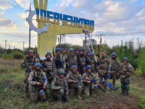 Ukrainian service members pose for in the recently liberated settlement of Vasylenkove, amid Russia's attack on Ukraine, in Kharkiv region, Ukraine, in this handout picture released September 10, 2022.