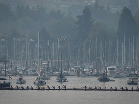 Smoke fills the air as paddlers in Indigenous war canoes prepare for a race on False Creek during the Four Fires Festival in Vancouver, on Sunday, Sept. 11, 2022.