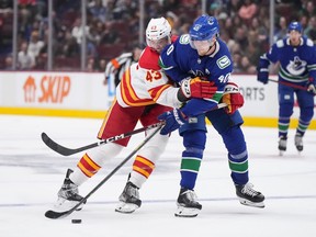 Calgary Flames' Adam Klapka, left, of the Czech Republic, ties up Vancouver Canucks' Elias Petterson, of Sweden, during the second period of a pre-season NHL hockey game in Vancouver, B.C., Sunday, Sept. 25, 2022.
