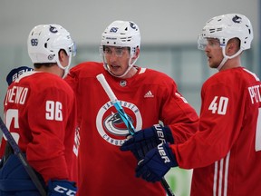 Vancouver Canucks' Ilya Mikheyev, centre, of Russia, talks to Andrei Kuzmenko, left, of Russia, and Elias Pettersson, of Sweden, during the NHL hockey team's training camp in Whistler, B.C., Thursday, Sept. 22, 2022.