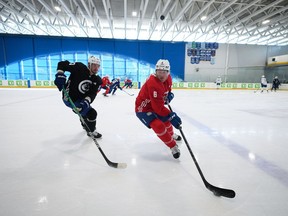 Vancouver Canucks' Brock Boeser, right, tries to keep the puck away from Oliver Ekman-Larsson, of Sweden, during the NHL hockey team's training camp in Whistler, B.C., Thursday, Sept. 22, 2022. The Vancouver Canucks right-winger struggled at times last season while dealing with the declining health of his father, Duke, but still managed 46 points (23 goals, 23 assists) in 71 games.