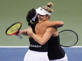 Canada's Gabriela Dabrowski, right, and Carol Zhao celebrate after defeating Latvia's Daniela Vismane and Darja Semenistaja during a Billie Jean King Cup qualifier doubles tennis match, in Vancouver, on Saturday, April 16, 2022.