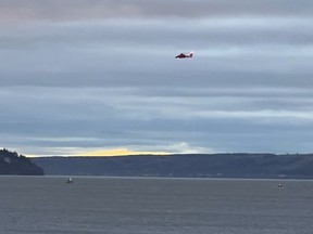 A Coast Guard helicopter searches the area where a floatplane crashed near Whidbey Island, Wash., Sunday, Sept. 4, 2022.