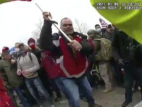 FILE - This still frame from Metropolitan Police Department body worn camera video shows Thomas Webster, in red jacket, at a barricade line at on the west front of the U.S. Capitol on Jan. 6, 2021, in Washington. Webster, a retired New York Police Department officer, is scheduled to be sentenced on Thursday, Sept. 1, 2022, for attacking the U.S. Capitol and using a metal flagpole to assault one of the police officers trying to hold off a mob of Donald Trump supporters. (Metropolitan Police Department via AP)
