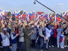 People react during celebrations marking the incorporation of the Donetsk region into Russia in Donetsk, Ukraine, Friday, Sept. 30, 2022.