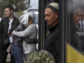 A Russian recruit and his wife kiss and hug each other outside a military recruitment center in Volgograd, Russia, Saturday, Sept. 24, 2022. Russian President Vladimir Putin on Wednesday ordered a partial mobilization of reservists to beef up his forces in Ukraine. (AP Photo)