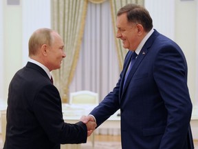 Russian President Vladimir Putin, left, and Milorad Dodik, the Serb member of Bosnia and Herzegovina's tripartite presidency, shake hands during a meeting in the Kremlin in Moscow, Russia, Tuesday, Sept. 20, 2022.
