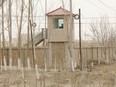 FILE - A security guard watches from a tower around a detention facility in Yarkent County in northwestern China's Xinjiang Uyghur Autonomous Region on March 21, 2021.