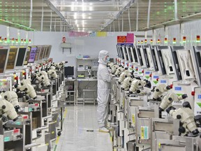 A man works at a manufacturer of Integrated Chip encapsulation in Nantong in eastern China's Jiangsu province on Friday, Sept. 16, 2022. Growth in Chinese factory activity was weak in September, export orders fell and employers cut jobs, two surveys showed Friday, Sept. 30, adding to pressure on lackluster economic growth (Chinatopix Via AP)