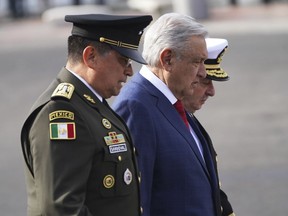 FILE - Mexican President Andres Manuel Lopez Obrador, center, Defense Secretary Luis Crescencio Sandoval, left, and Navy Secretary Vidal Francisco Soberon walk through the Zocalo during the Independence Day military parade in Mexico City, Sept. 16, 2022. A massive trove of emails from Mexico's Defense Department is among electronic communications taken by a group of hackers from military and police agencies across several Latin American countries, Obrador confirmed Friday, Sept. 30.