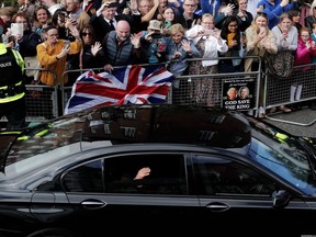 Britain's King Charles III waves to the public as he leaves after a visit to Hillsborough Castle, Northern Ireland, Tuesday, Sept. 13, 2022.