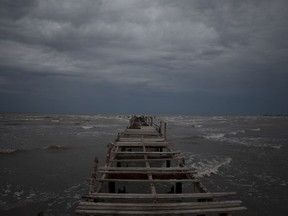Waves kick up under a dark sky along the shore of Batabano, Cuba, Monday, Sept. 26, 2022. Hurricane Ian was growing stronger as it approached the western tip of Cuba on a track to hit the west coast of Florida as a major hurricane as early as Wednesday.