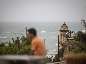 A man stands in front of a beach before the arrival of Tropical Storm Fiona in San Juan, Puerto Rico, Saturday, Sept. 17, 2022. Fiona was expected to become a hurricane as it neared Puerto Rico on Saturday, threatening to dump up to 20 inches (51 centimeters) of rain as people braced for potential landslides, severe flooding and power outages.