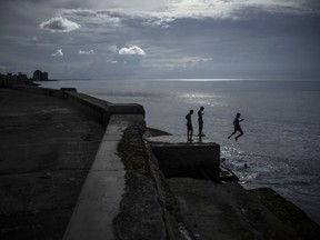 Boys spend the afternoon jumping into the water from the sea wall or the Malecon in Havana, Cuba, Thursday, Sept. 15, 2022.