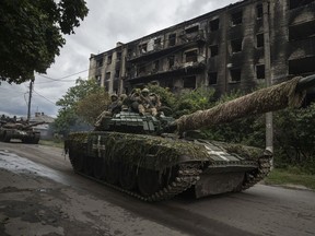 Ukrainian servicemen drive atop a tank in the recently retaken area of Izium, Ukraine, Wednesday, Sept. 14, 2022.