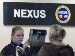 A Canada Border Services Agency officer speaks with a traveller at the Nexus office at the airport in Ottawa, Tuesday, May 8, 2012.