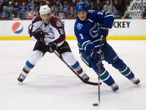 Vancouver Canucks' Kevin Bieksa, right, skates with the puck as Colorado Avalanche's Paul Stastny gives chase during first period NHL hockey action in Vancouver, B.C., on Thursday April 10, 2014. Defenceman Kevin Bieksa will sign a one-day contract with the Vancouver Canucks to mark his retirement from the NHL on Nov. 3, the team announced on Thursday.