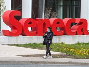 A pedestrian wearing a mask walks past Seneca College signage in Scarborough during the Covid 19 pandemic, Wednesday May 5, 2021. Peter J Thompson/ National Post)