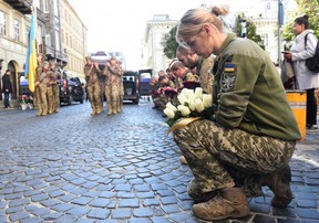 Ukrainische Soldaten knien, während die Särge von Roman Vyshynskyi, Yuriy Lelyavskyi und Ihor Hadyak – drei Soldaten, die im Kampf gegen die Russen getötet wurden – während einer Trauerfeier am Freitag in Lemberg getragen werden.