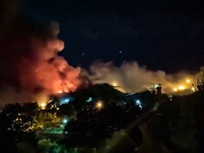 This image grab from a UGC video made available on October 15, 2022, reportedly shows flames and thick smoke rising from the Evin prison, in the northwest of the Iranian capital Tehran.